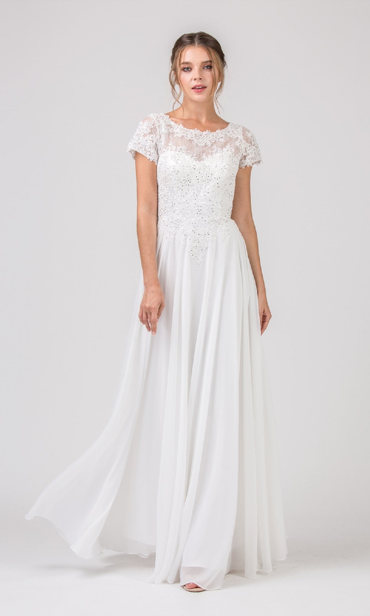 A woman wears the Eureka 4909 Short-Sleeve Long A-Line Formal Dress in white, featuring an embroidered lace bodice and flowing chiffon skirt, standing against a plain background.